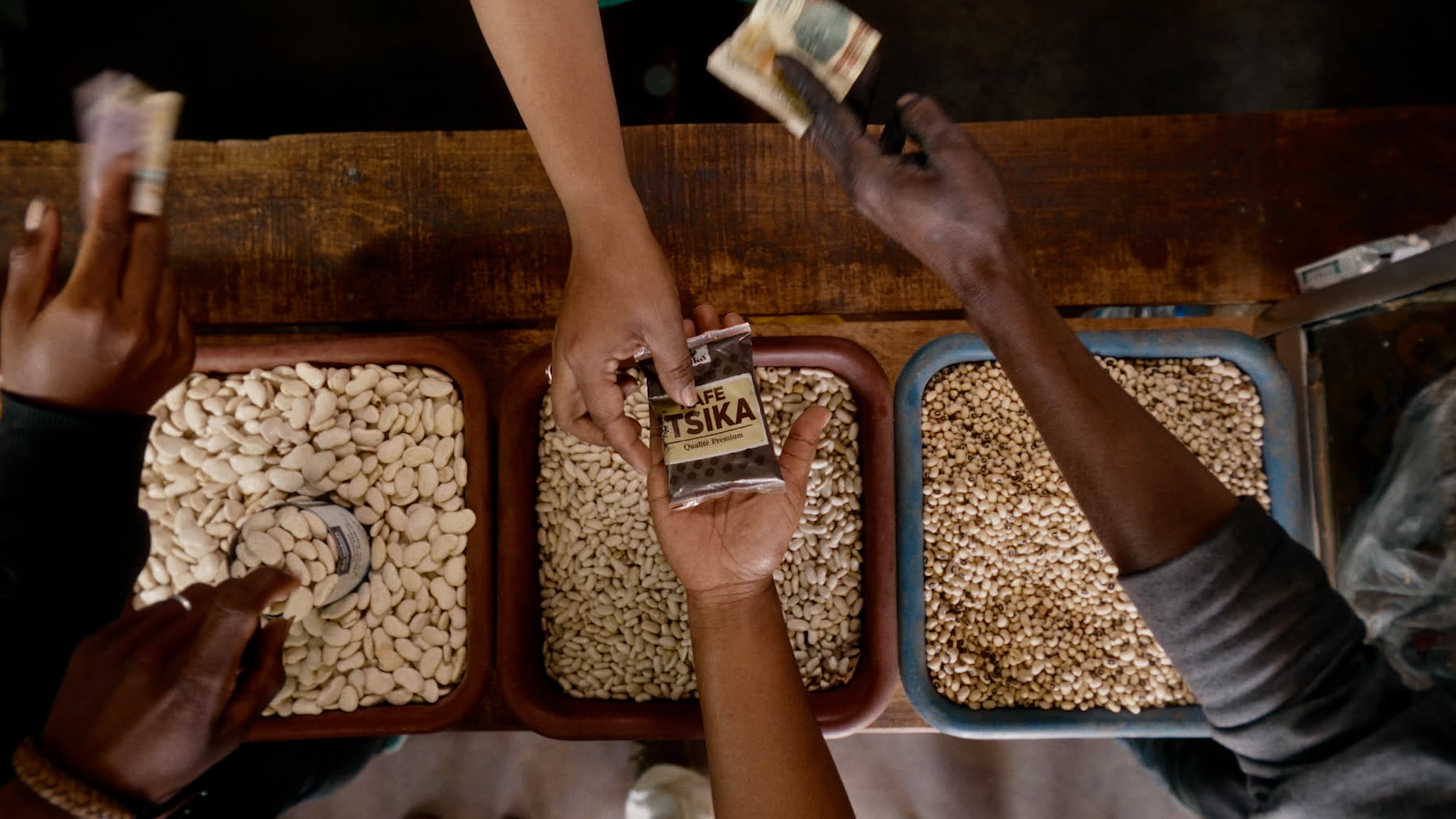 Des mains se servent dans des bacs de grains, vue de dessus